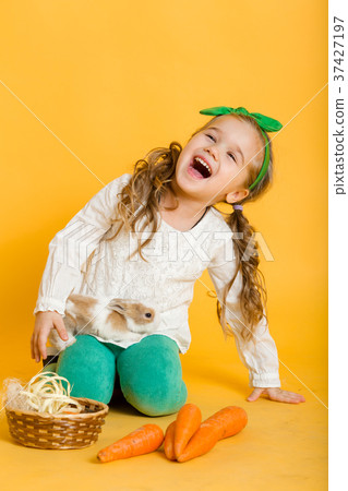 Pretty happy child girl with carrots and her 37427197