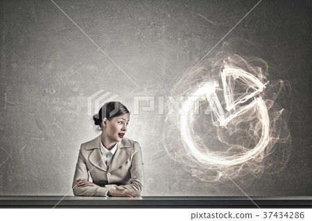 Attractive businesswoman sitting at table Attractive businesswoman sitting at table 37434286