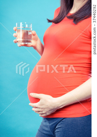 Pregnant woman with glass of water 37440292