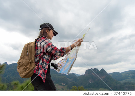 Asia woman traveler with backpack checks map Asia woman traveler with backpack checks map 37440775