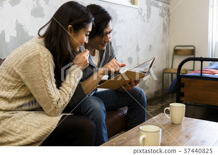 Young couple looking at an album Young couple looking at an album 37440825