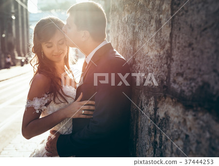 Handsome groom is kissing his charming bride in Handsome groom is kissing his charming bride in 37444253