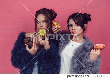 Beautiful girls with donuts posing on pink 37449035