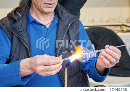 Glass master hands heat up the glass rod. Glass master hands heat up the glass rod. 37449398