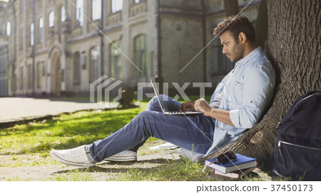 Multinational young man reading information on Multinational young man reading information on 37450173
