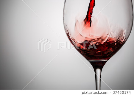 Pouring red wine into transparent glass Pouring red wine into transparent glass 37450174