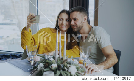 Happy smiling couple having lunch and taking 37450917
