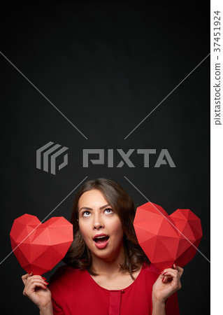 Smiling woman holding two polygonal heart shape 37451924