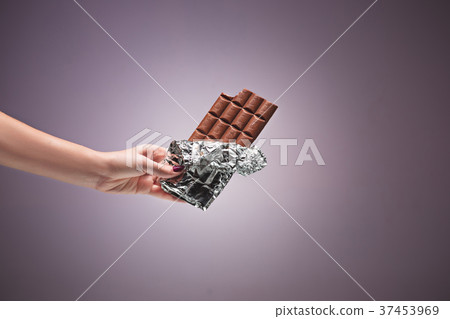 Hands of a woman holding a tile of chocolate Hands of a woman holding a tile of chocolate 37453969