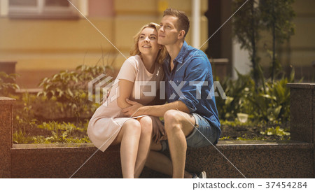 Romantic couple sitting on bench and looking into 37454284