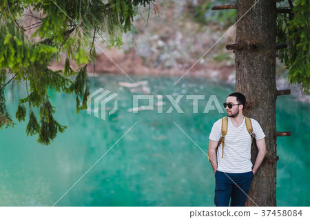 Bearded man model poses alongside a Green water Bearded man model poses alongside a Green water 37458084