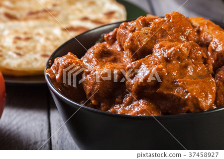 Chicken tikka masala served with bread naan 37458927