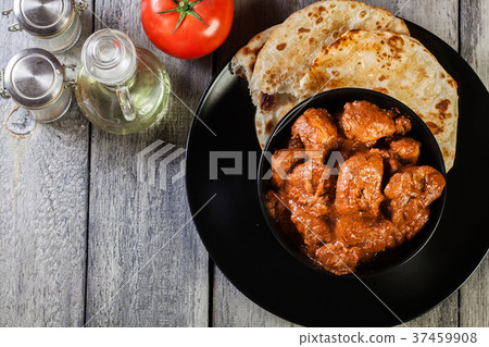 Chicken tikka masala served with bread naan 37459908