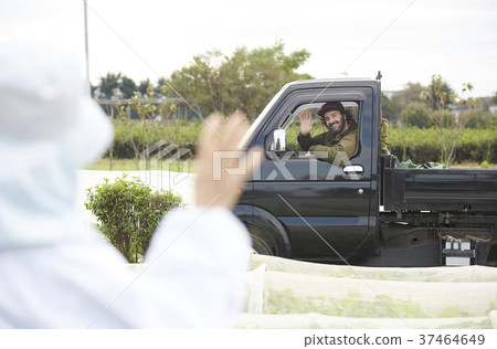 Foreigner driving a truck with a woman working in farming 37464649