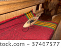 Traditional weaving and a shuttle on machine 37467577
