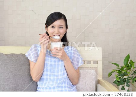 Woman eating yogurt 37468138
