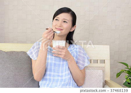Woman eating yogurt 37468139