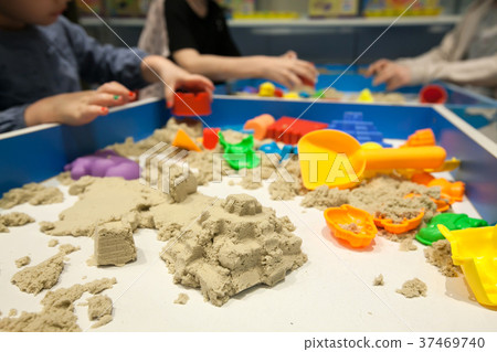 Kids playing plastic mold toy with sand on sandbox Kids playing plastic mold toy with sand on sandbox 37469740