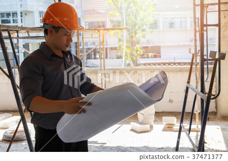 Engineer with blueprint in construction site 37471377