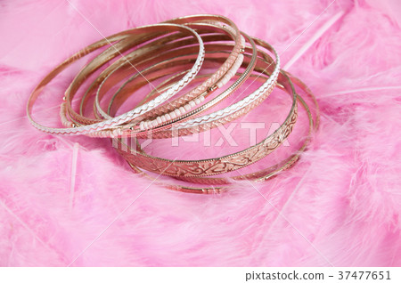 Many bracelets on pink 37477651