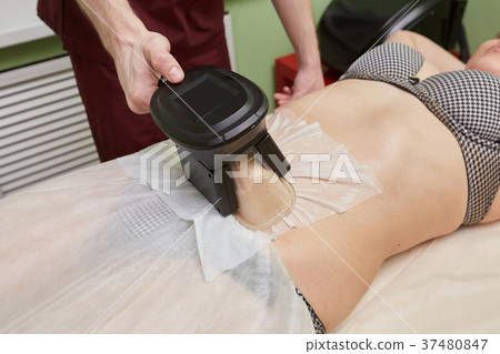 Woman getting cryolipolysis fat treatment Woman getting cryolipolysis fat treatment 37480847