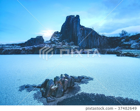 Volcanic rocky hill covered by snow during winter Volcanic rocky hill covered by snow during winter 37482649