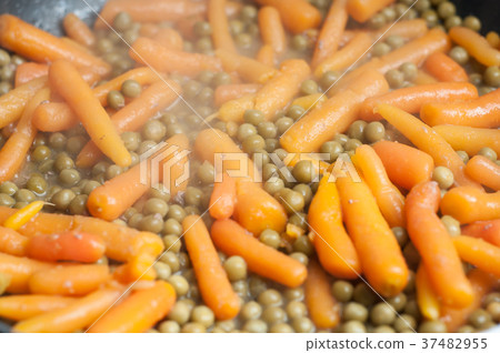 closeup of green peas and carrots in stove closeup of green peas and carrots in stove 37482955