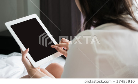 Asian woman use a tablet on the bed Asian woman use a tablet on the bed 37485910