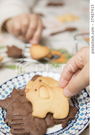 Child hand eating homemade cookies Child hand eating homemade cookies 37487415