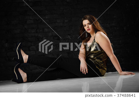 plus size model in a gold blouse and black jeans plus size model in a gold blouse and black jeans 37488641