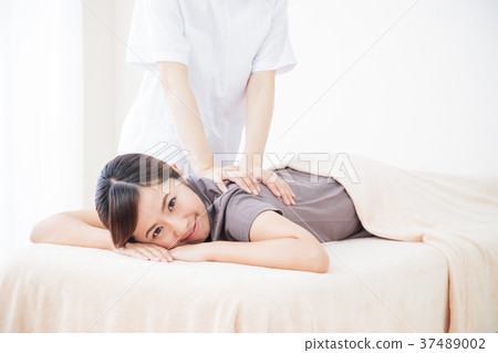 按摩秀麗治療人身體按摩脊柱治療者女性耐心白色背景 按摩秀麗治療人身體按摩脊柱治療者女性耐心白色背景 37489002