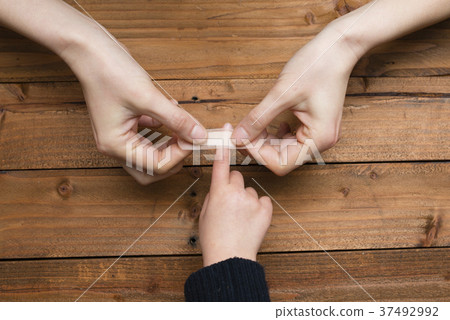 Mother's hand putting a plaster on a child's hand 37492992