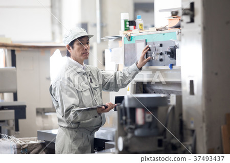 Male worker operating a town factory/machine Male worker operating a town factory/machine 37493437
