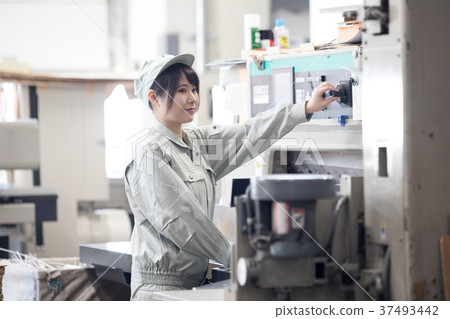 Young female worker operating a town factory / machine 37493442