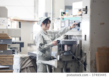 Young female worker operating a town factory / machine Young female worker operating a town factory / machine 37493445