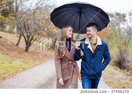 a guy with a girl in the Park of autumn rain a guy with a girl in the Park of autumn rain 37496279