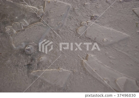 A frozen puddle of muddy water on the road. A frozen puddle of muddy water on the road. 37496830