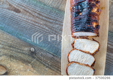 Pork loin wrapped in bacon on the wooden board 37500266