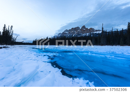 Blue glacier water flowing over ice in the bow 37502306