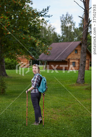 young woman with nordic walk pols 37502938