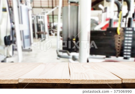 Wooden table on blurred background of fitness gym interior of mo Wooden table on blurred background of fitness gym interior of mo 37506990