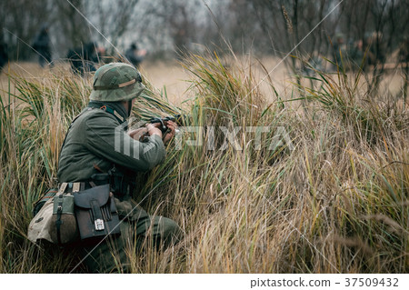 German soldier Wehrmacht sits in hiding with rifle 37509432