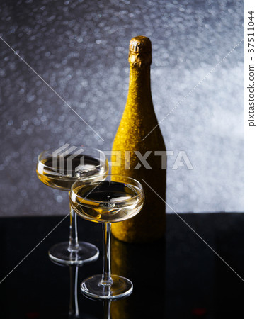 Festive photo of bottle of champagne in gold Festive photo of bottle of champagne in gold 37511044