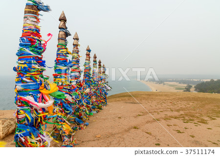 Wooden ritual pillars with colorful ribbons Hadak 37511174