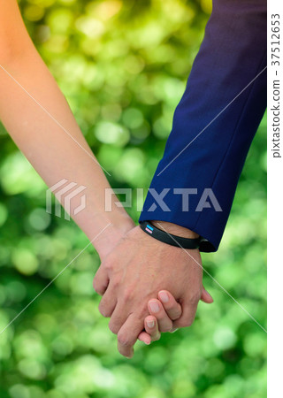 The bride and groom join hands. 37512653