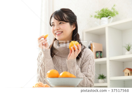 woman eating mandarin oranges woman eating mandarin oranges 37517568