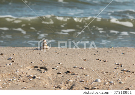 Pyramid is made of white stones of sea waves. 37518991