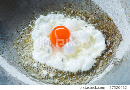 Fried salted egg with oil in hot pan. Fried salted egg with oil in hot pan. 37520412