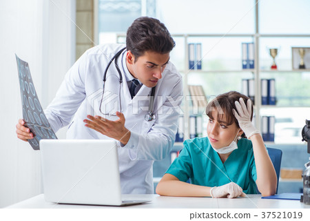 Two doctors discussing x-ray MRI image in hospital 37521019