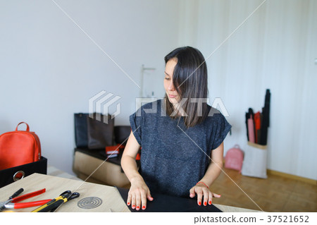 Girl working with belt at clothing repair. 37521652